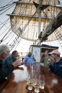 Ireland, July 2013. The Battle of the whiskies with Ales Moens, chairman of the Flemish Singe Malt Society. Single malt Scotch Whisky versus triple distilled Irish Whiskey. It is the first time that Tallship Thalassa, a barquentine sailing vessel with 3 masts, sails from Belfast to Galway along the Irish coastline. While a full-rigged ship is square-rigged on all three masts, and the barque is square-rigged on the foremast and main, the barquentine extends the principle by making only the foremast square-rigged. The advantages of a smaller crew, good performance before the wind and the ability to sail relatively close to the wind while carrying plenty of cargo made it a popular rig at the end of the 19th century. Photo by Frits Meyst/Adventure4ver.com